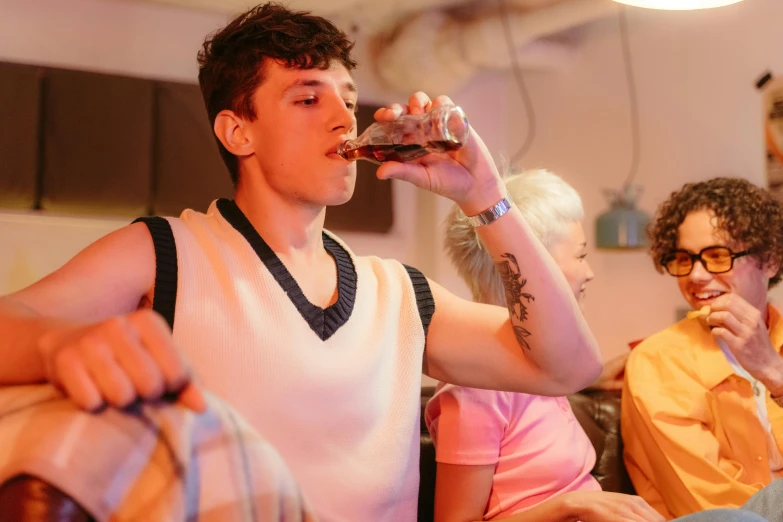 a man sitting on a couch drinking a glass of wine, pexels contest winner, renaissance, wearing a vest top, college party, at a 5 0 s diner, declan mckenna