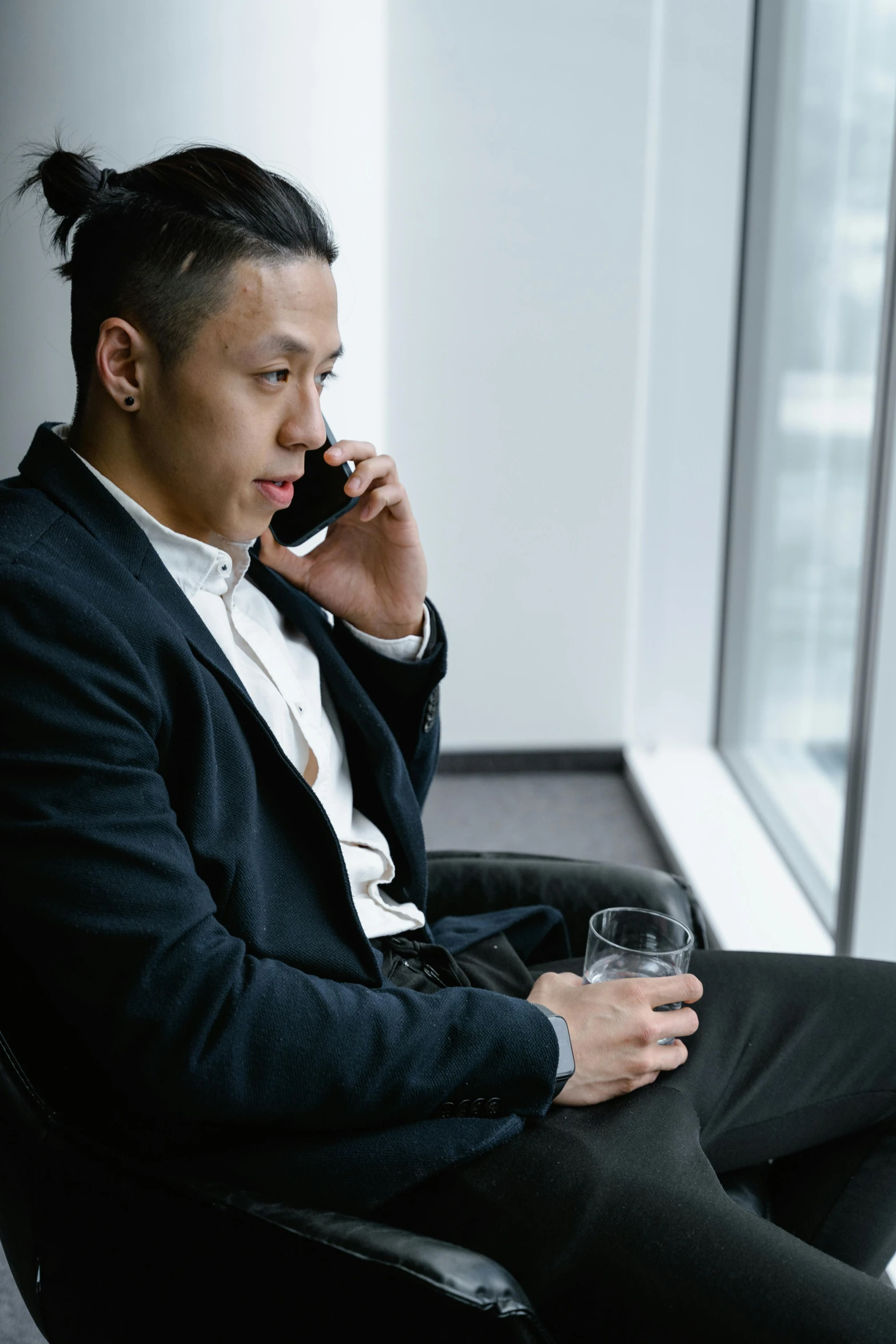 a man sitting in a chair talking on a cell phone, inspired by Fei Danxu, pexels contest winner, realism, wearing causal black suits, drinking, asian male, like andy lau