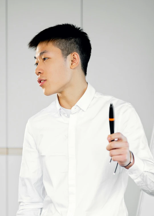 a man in a white shirt is holding a pen, inspired by Ding Guanpeng, reddit, profile image, ready to model, standing in class, 🦑 design
