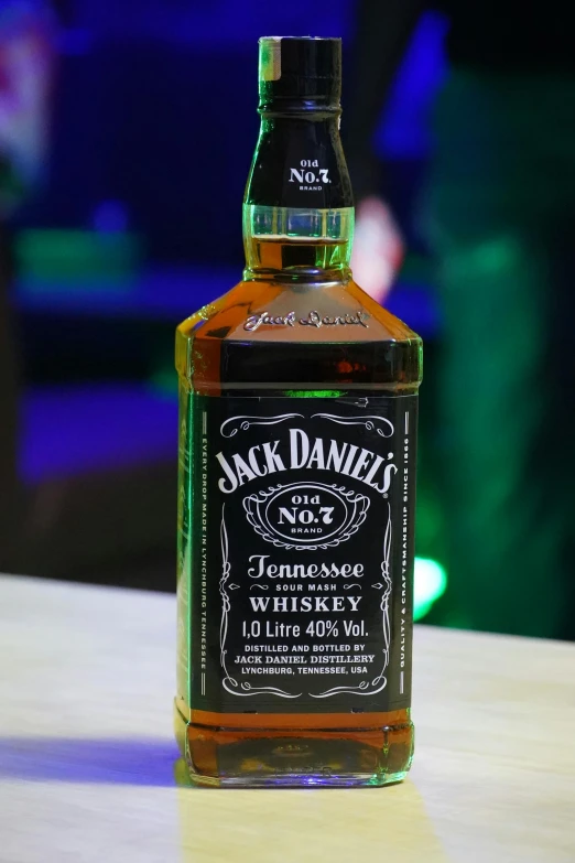a bottle of jack daniels whiskey sitting on a table, pexels, photorealism, on stage, black and green, top 4 0, shot on webcam