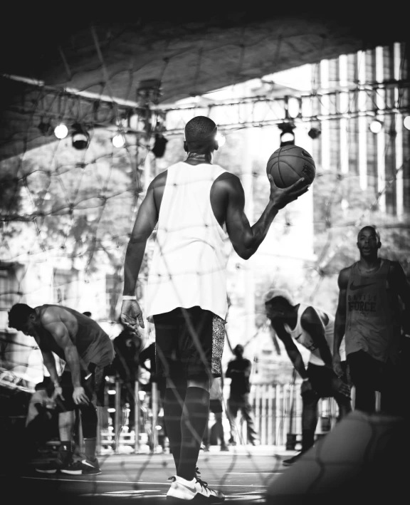 a black and white photo of a man holding a basketball, by Kristian Kreković, unsplash contest winner, in front of a large crowd, harlem, performing, shady