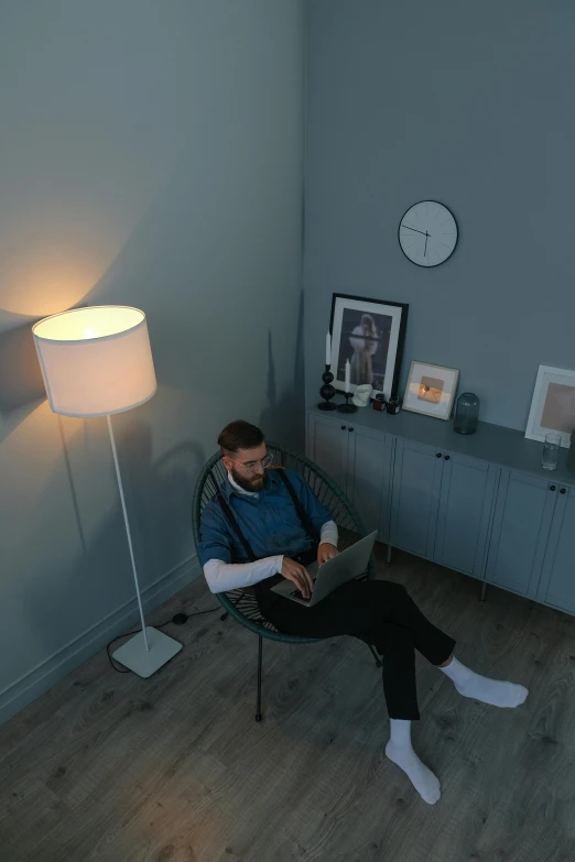 a man sitting in a chair using a laptop, trending on reddit, floor lamps, high-quality photo, single portrait, hziulquoigmnzhah