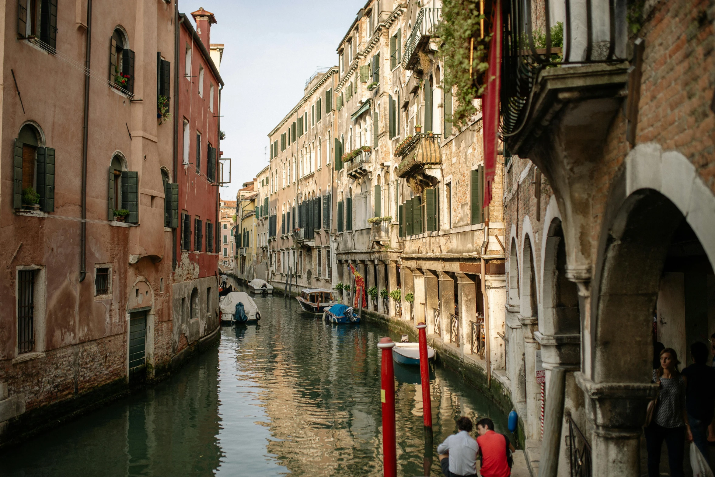 a canal filled with lots of boats next to tall buildings, by Carlo Martini, pexels contest winner, renaissance, olive green and venetian red, people walking around, fine art print, 2022 photograph