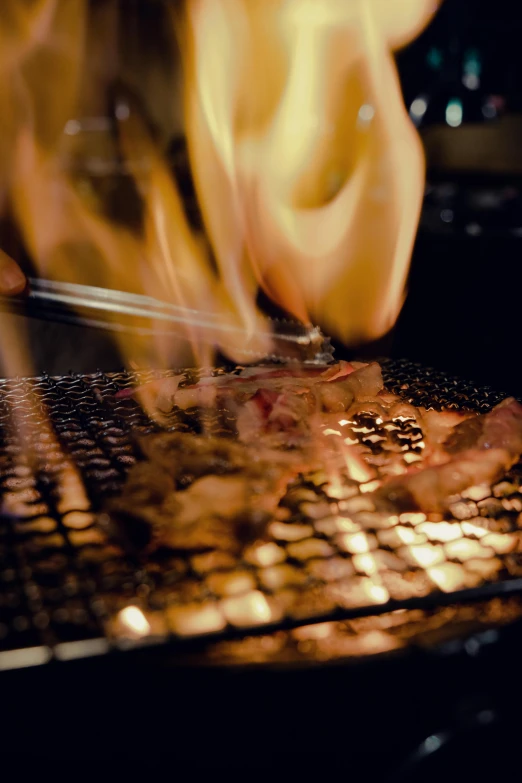 a close up of a person cooking food on a grill, ukiyo, flaming heart, nightlife, grey