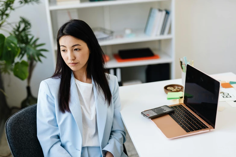 a woman sitting in front of a laptop computer, trending on pexels, hurufiyya, wearing a worn out suit, nanae kawahara, female in office dress, wearing lab coat and a blouse