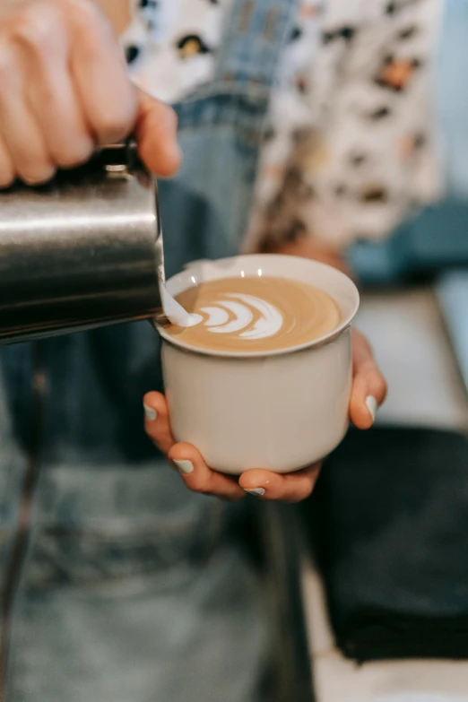 a person pouring a cup of coffee into a cup, by Austin English, cream, swirly, thumbnail, cafe