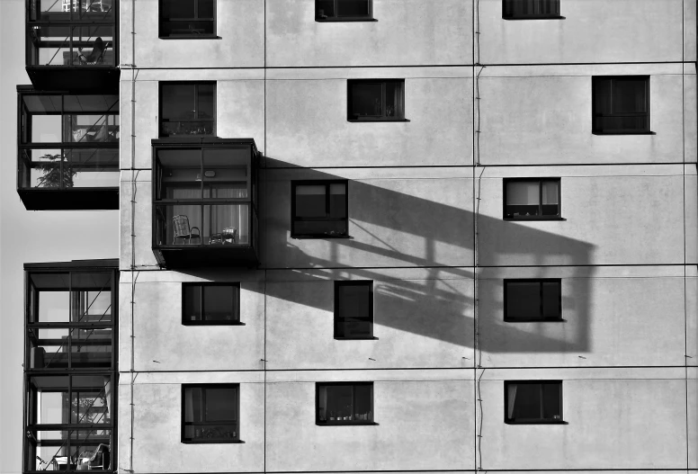 a black and white photo of an apartment building, a photo, inspired by André Kertész, flickr, consist of shadow, modern high sharpness photo, sun light, modern photo