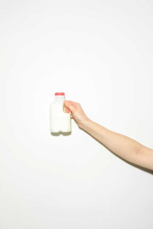 a person holding a bottle of milk in their hand, by Doug Ohlson, minimalism, kailee mandel, small, transparent, farm