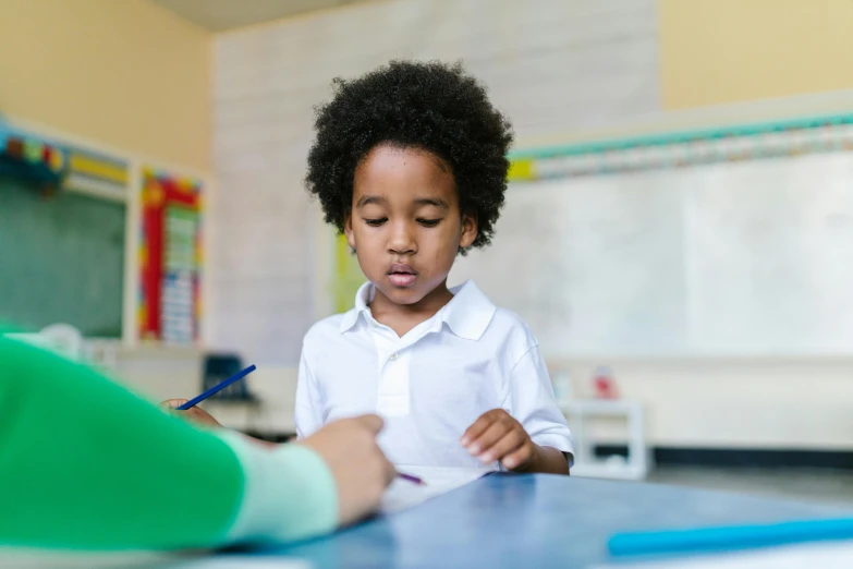 a little boy sitting at a desk writing on a piece of paper, pexels contest winner, ashcan school, black man with afro hair, standing in class, reaching out to each other, lachlan bailey