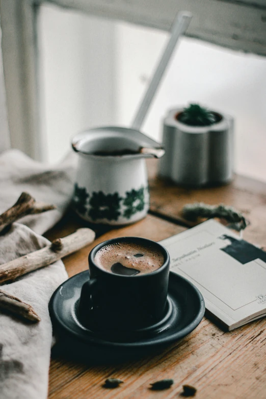 a cup of coffee sitting on top of a wooden table, a still life, pexels contest winner, cozy aesthetic, multiple stories, botanicals, abcdefghijklmnopqrstuvwxyz