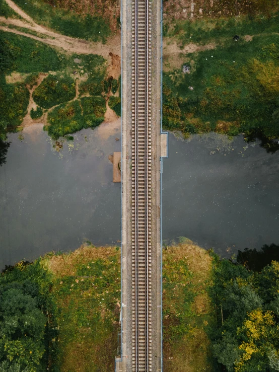 an aerial view of a train track next to a river, pexels contest winner, 4 k symmetrical portrait, from waist up, photo 8 k, multiple stories