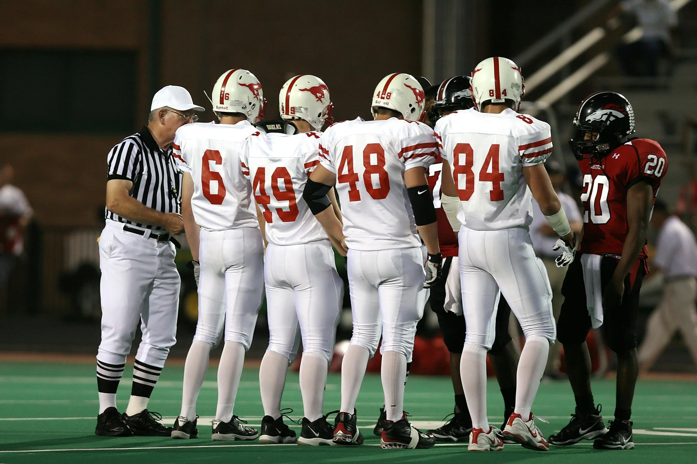 a group of football players standing on top of a field, david kostic, sports photo, whitehorns, ap news photo