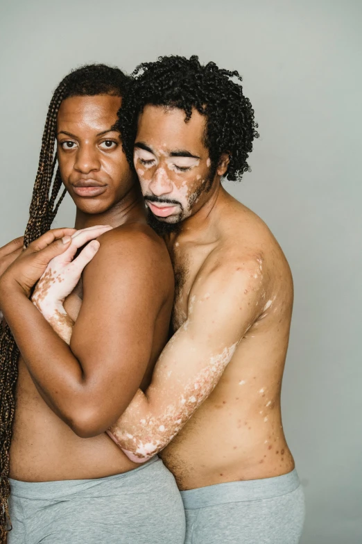 a man and a woman standing next to each other, brown skin like soil, milk bath photography, two men hugging, slide show