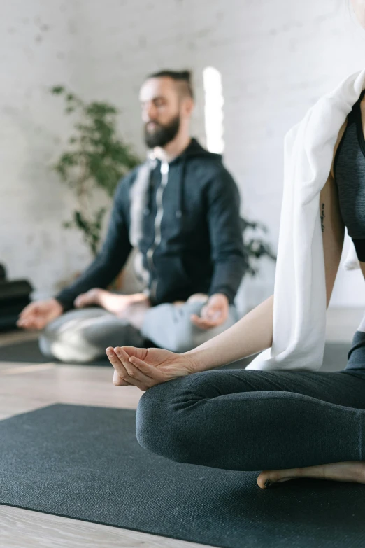 a group of people sitting on top of a yoga mat, wearing a grey robe, thumbnail, figure meditating close shot, full - body artwork