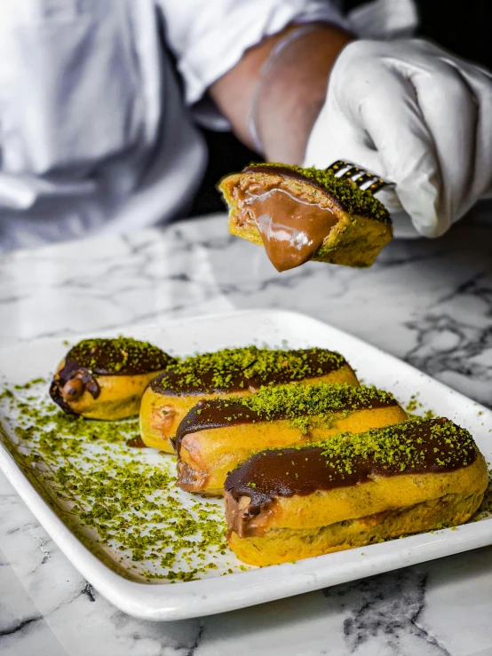 a close up of a plate of food on a table, cake in hand, sayem reza, with a long, yellow charcoal