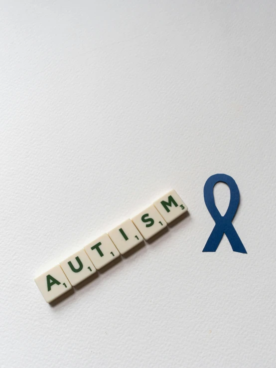 the word autism spelled in scrabbles next to a blue ribbon, by Harriet Zeitlin, trending on reddit, visual art, unsplash photo contest winner, 🤬 🤮 💕 🎀, but minimalist, signs