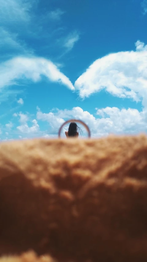 a person standing on top of a sandy beach, by Robbie Trevino, pexels contest winner, land art, heart eyes, girl clouds, world seen only through a portal, profile image