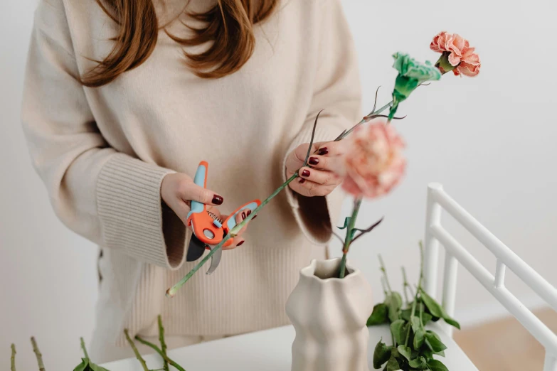 a woman cutting a flower with a pair of scissors, trending on pexels, miniature product photo, pteranadon styling, giant mechanical rose, teal and orange colours