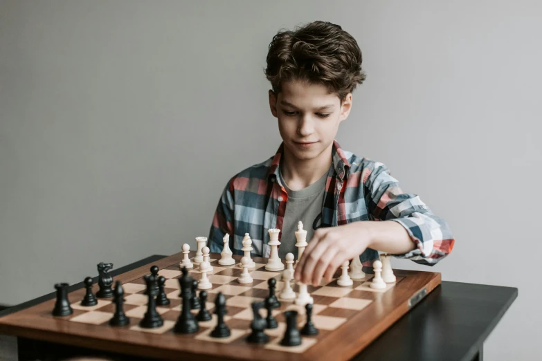 a young boy playing a game of chess, a portrait, pexels contest winner, 15081959 21121991 01012000 4k, 1 6 years old, ignant, board games on a table