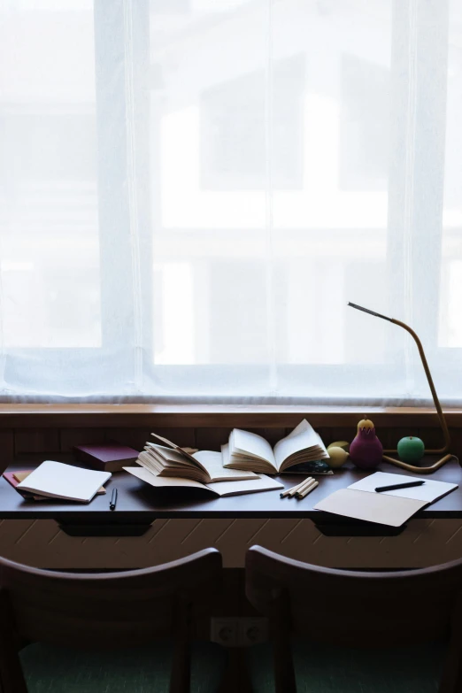 a table that has a bunch of papers on it, a still life, unsplash, lit windows, shigeto koyama, open books, dwell