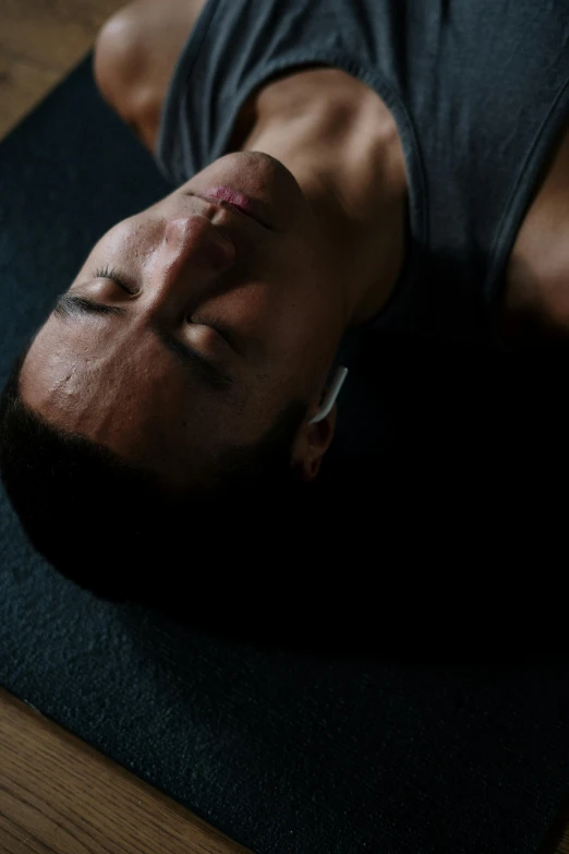 a man laying on a yoga mat with his eyes closed, unsplash, hyperrealism, cinematic film still, asian male, epk, ignant