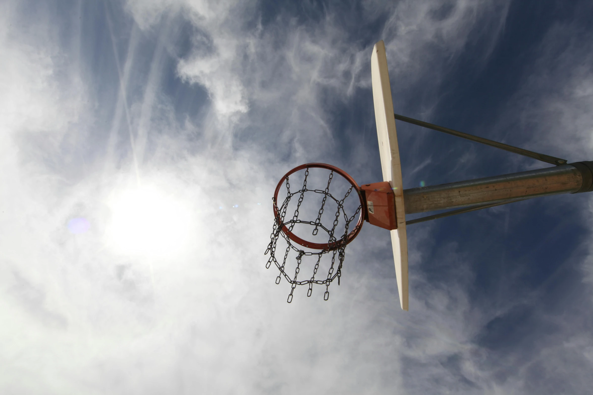 a basketball hoop in the middle of a cloudy sky, an album cover, by Matthias Stom, unsplash, photorealism, in the sun, let's play, shot on sony alpha dslr-a300, view from below