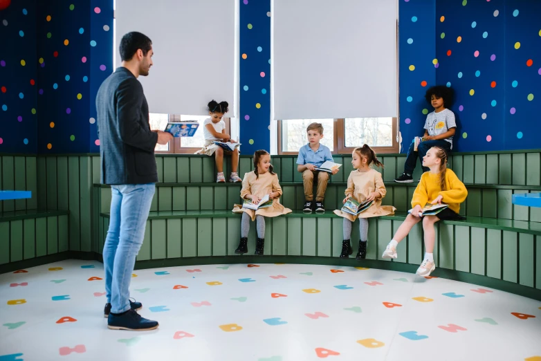 a man standing in front of a group of children, inspired by david rubín, pexels contest winner, danube school, conversation pit, storybook style, studying in a brightly lit room, hexagonal shaped