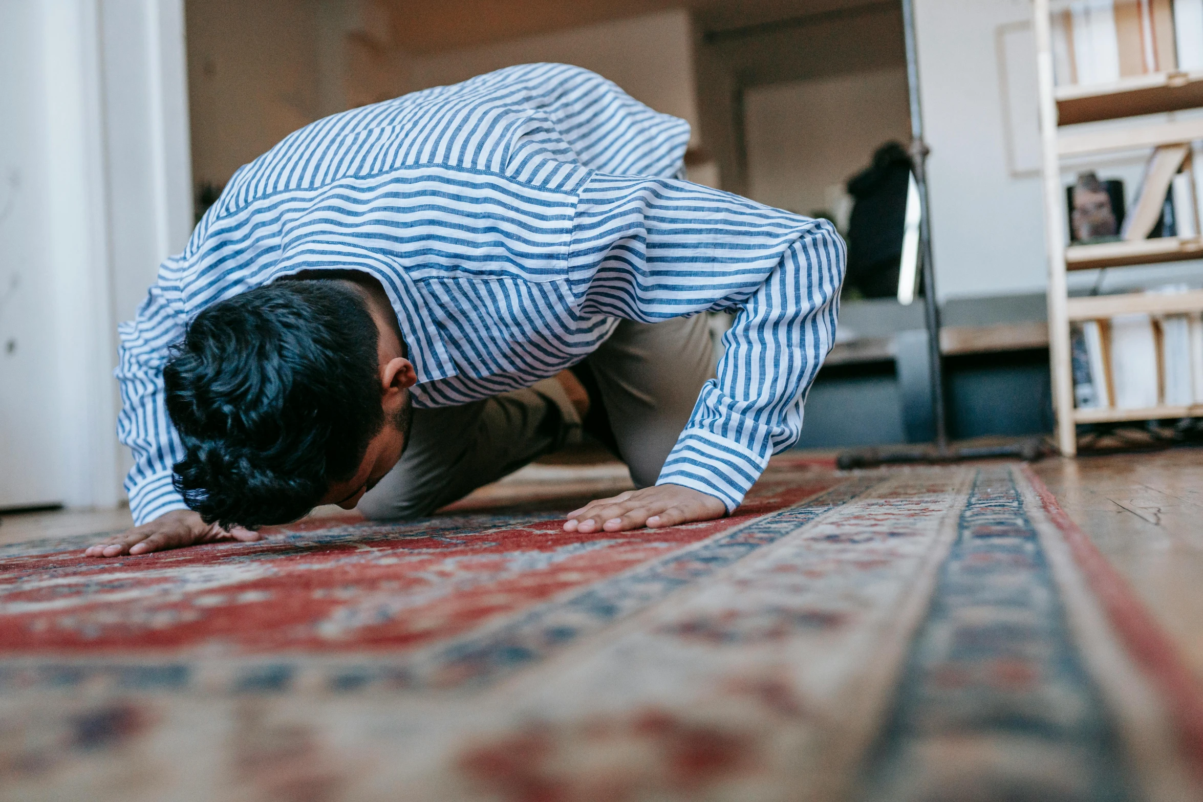 a man bending over on a rug in a living room, unsplash, hurufiyya, doing a prayer, 2 5 6 x 2 5 6, neck up, mosque