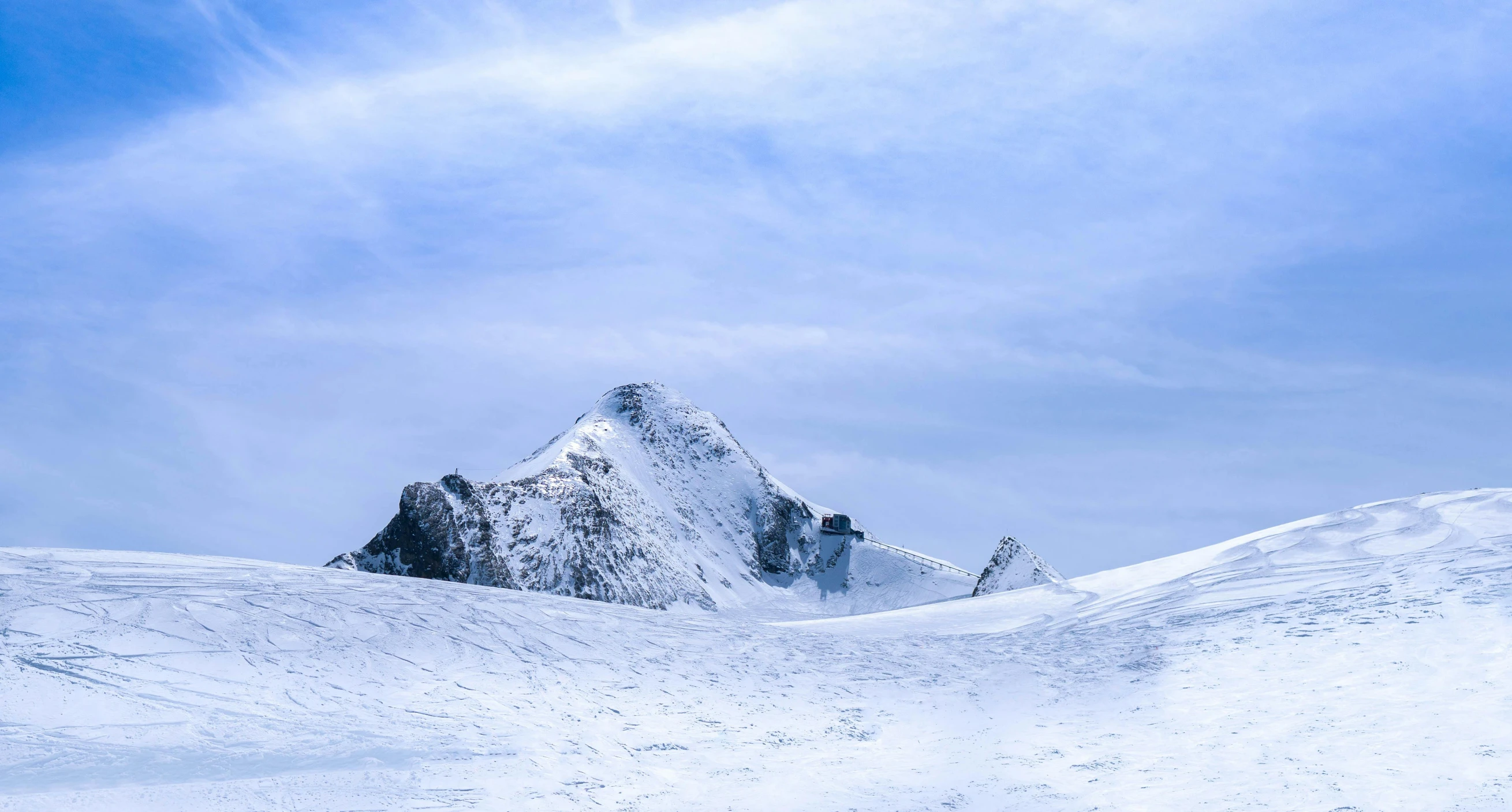 a man riding skis down a snow covered slope, an album cover, by Peter Churcher, pexels contest winner, ice mountains afar, blue glacier, brown, photos