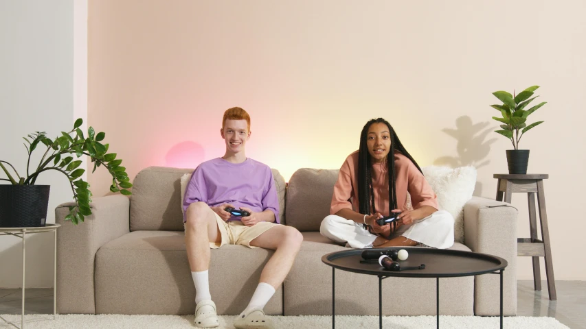 a man and a woman sitting on a couch, trending on pexels, led gaming, pastel lighting, product introduction photo, mixed race