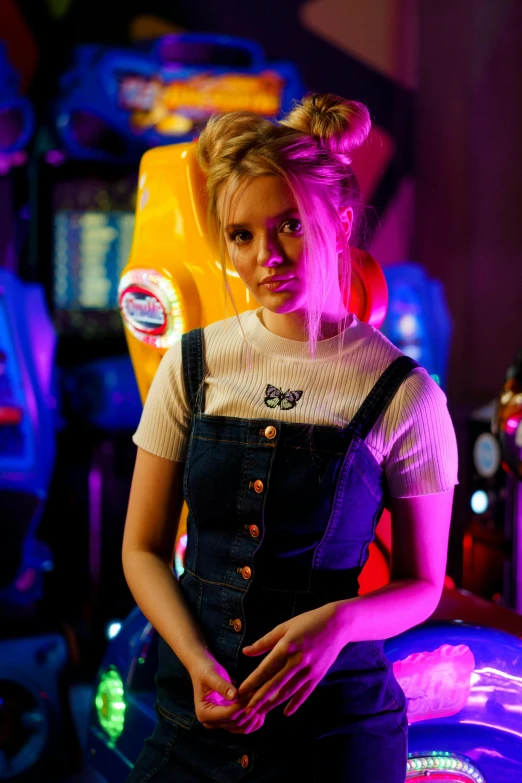 a woman standing in front of a game machine, trending on cg society, wearing blue jean overalls, sydney sweeney, neon lights in the background, pretty pretty face