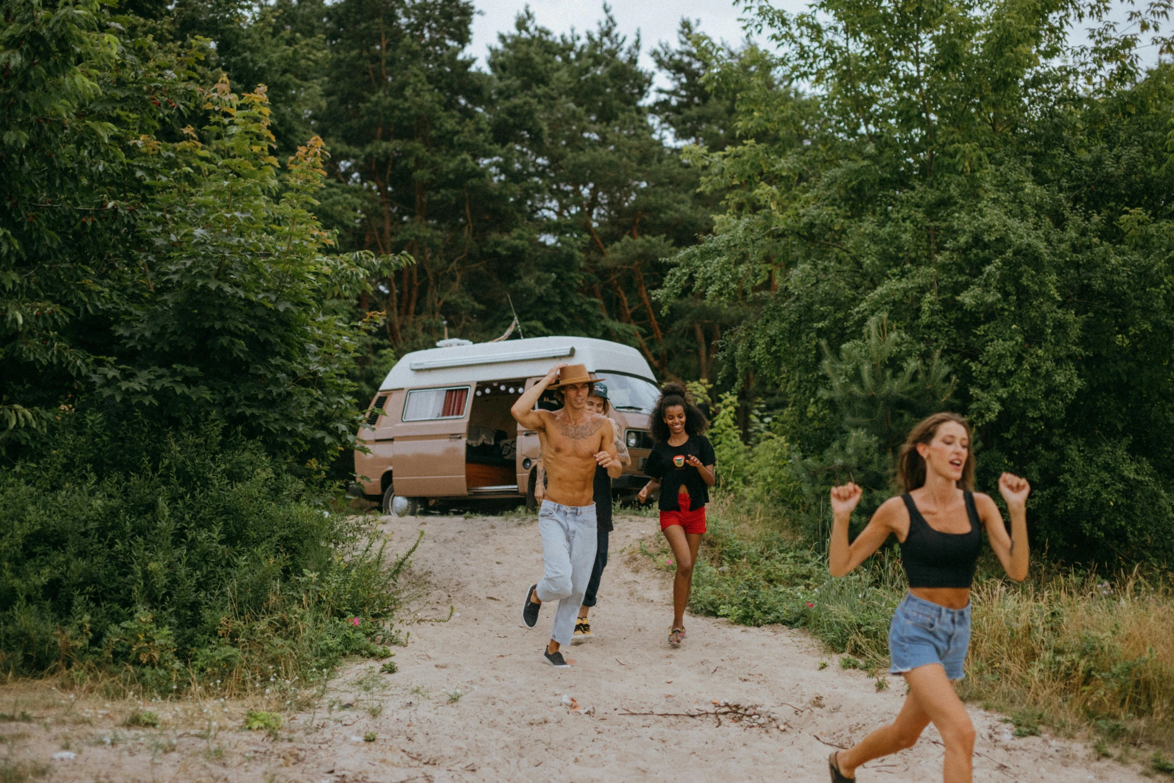 a group of people running down a dirt road, next to an rv, summer vibe, avatar image, jovana rikalo