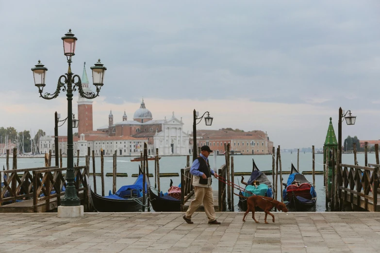 a man walking a dog in front of a row of gondolas, inspired by Canaletto, pexels contest winner, fishing, 15081959 21121991 01012000 4k, high resolution photo, il