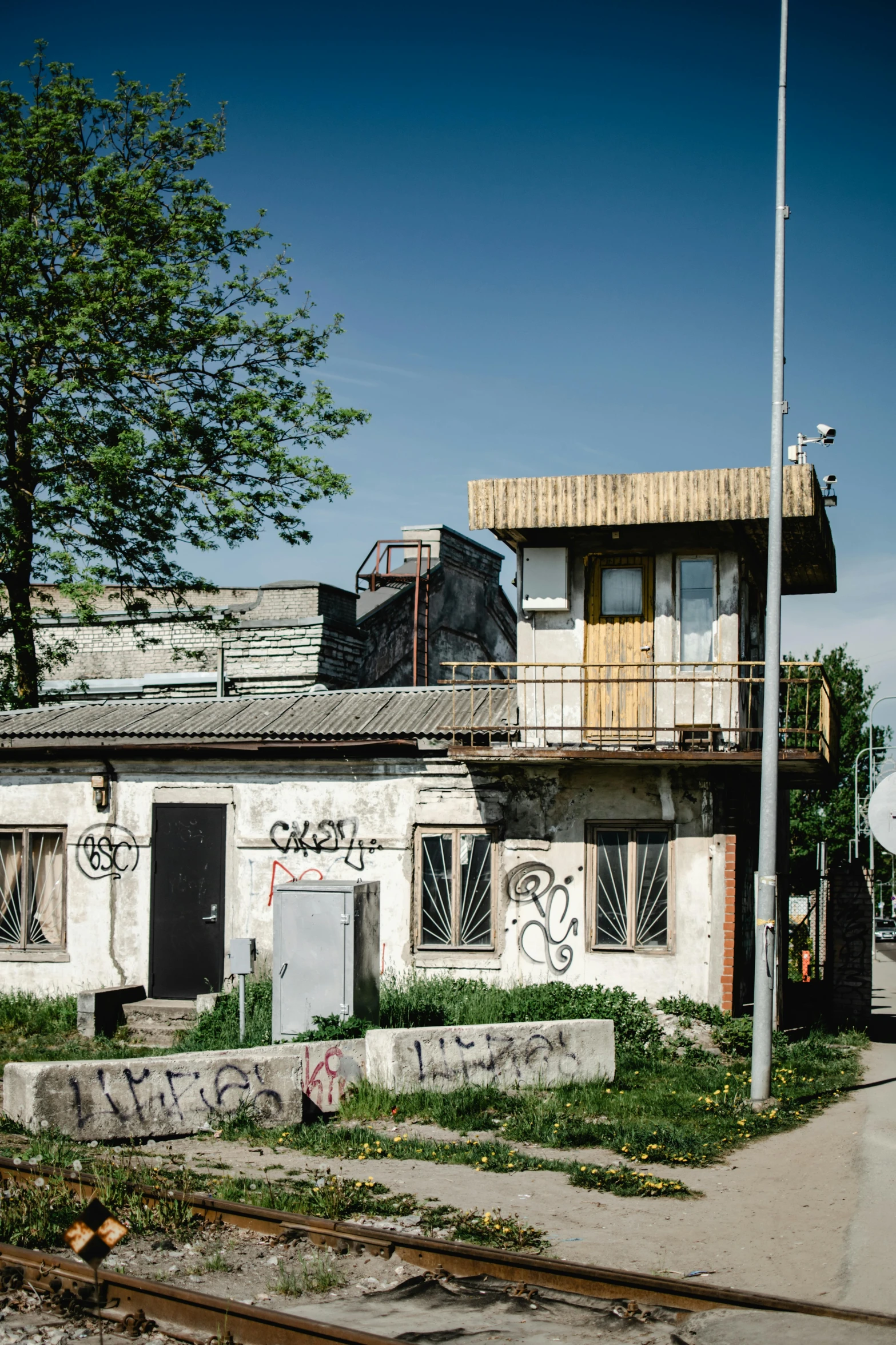 a train station with graffiti on the side of it, by Adam Marczyński, wooden house, post - soviet courtyard, 2022 photograph, square