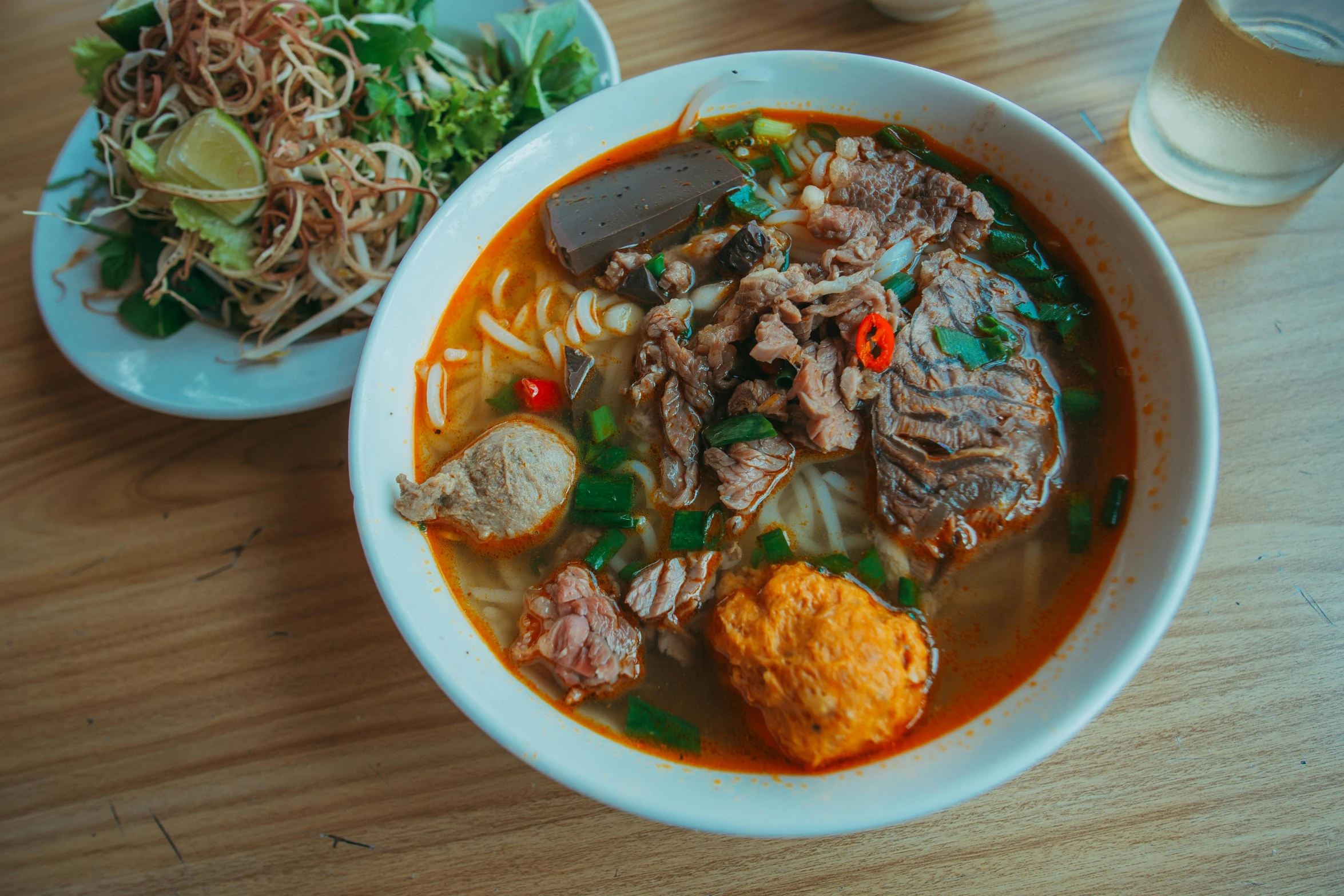 a bowl of soup sitting on top of a wooden table, inspired by Tan Ting-pho, pexels contest winner, square, beef, hyperdetailed colourful, street life