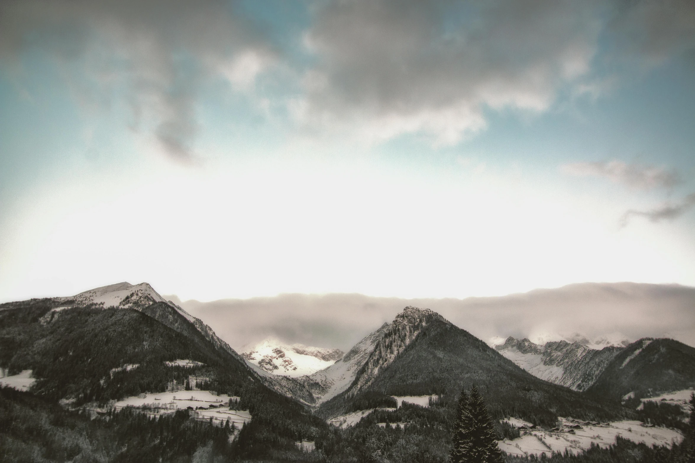 a man riding a snowboard down a snow covered slope, a picture, pexels contest winner, visual art, ominous! landscape of north bend, distant mountains lights photo, gray clouds, landscape wallpaper