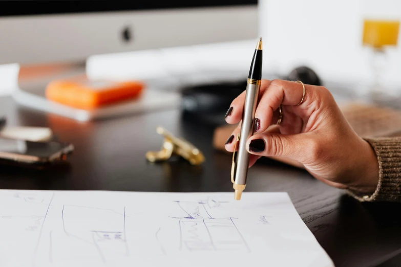 a person sitting at a desk with a pen and paper, a drawing, 9 9 designs, curated collections, trending photo, building plans