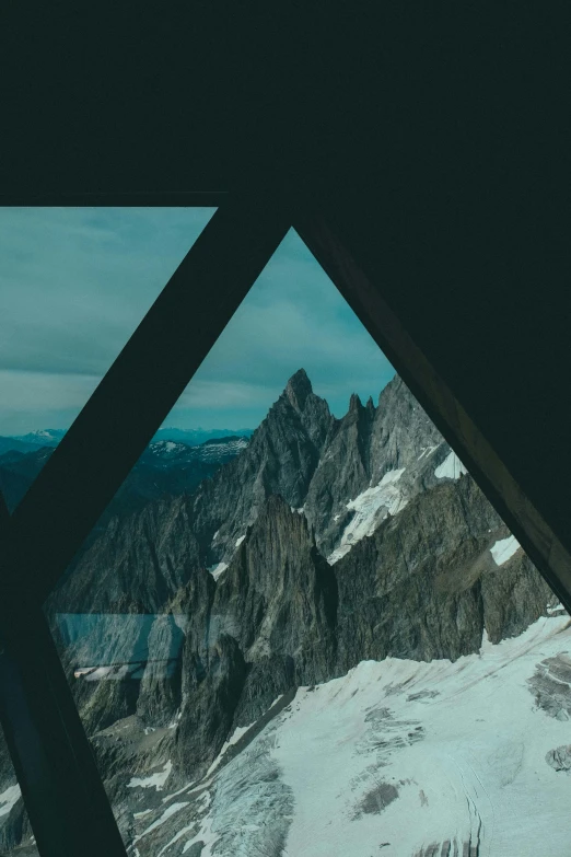 a view of a snow covered mountain through a window, pexels contest winner, modernism, asymmetrical spires, dark mountains, symmetrical outpost, swiss modernizm