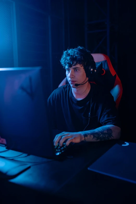 a man sitting at a desk in front of a computer, e-sport style, 2 1 savage, halfbody headshot, performing