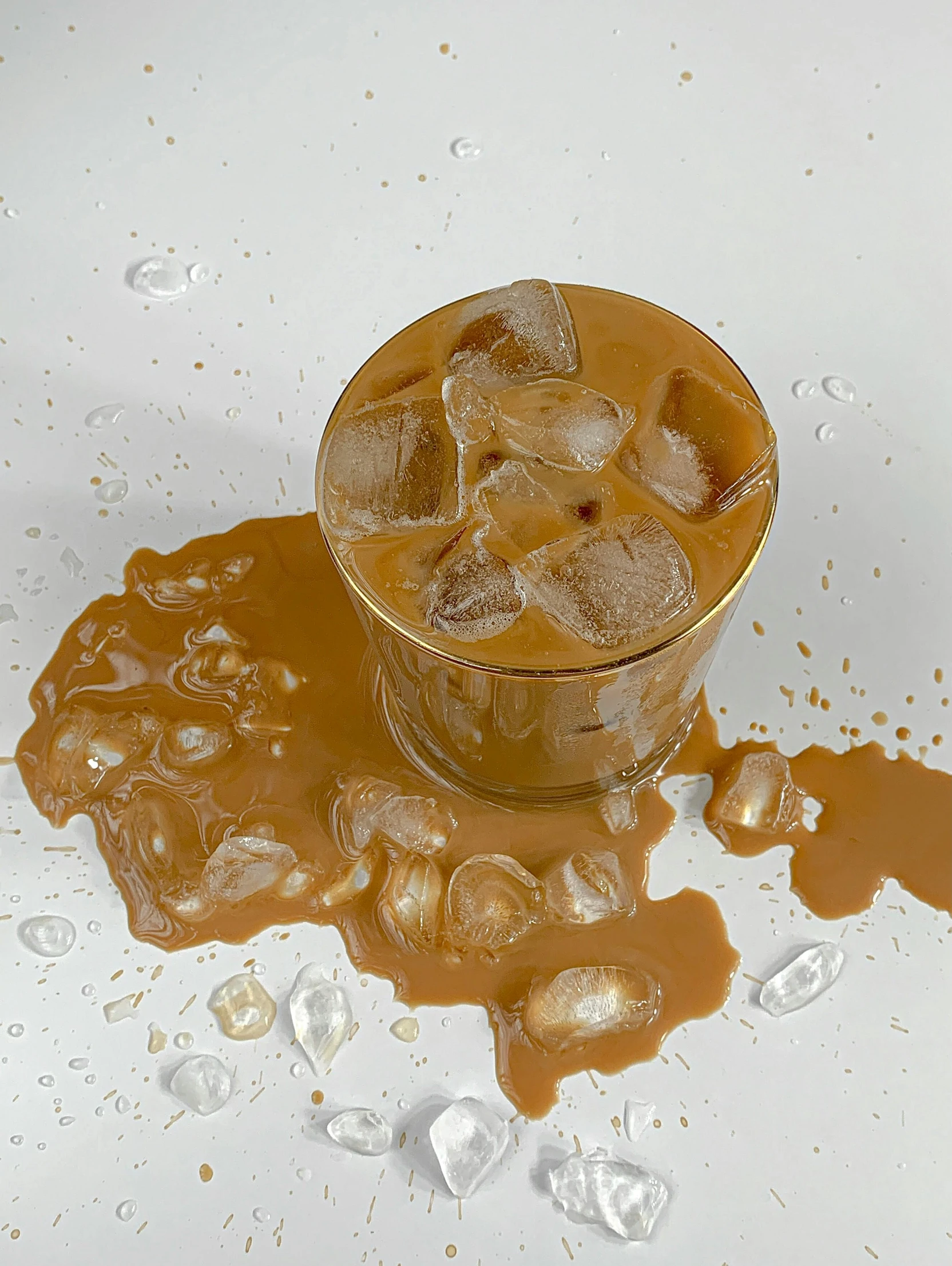 a glass filled with ice sitting on top of a table, caramel, detailed product image, coffee stain, thumbnail