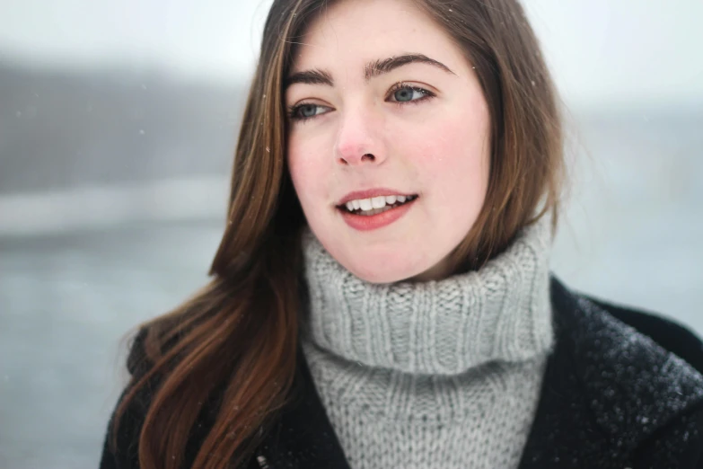 a woman standing in front of a body of water, inspired by Louisa Matthíasdóttir, pexels contest winner, realism, white cheeks, in winter, handsome girl, closeup headshot