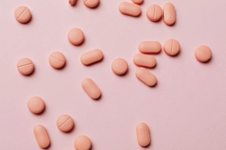 pink pills scattered on a pink surface, trending on pexels, antipodeans, covered in coral, trending on dezeen, medical labels, terracotta