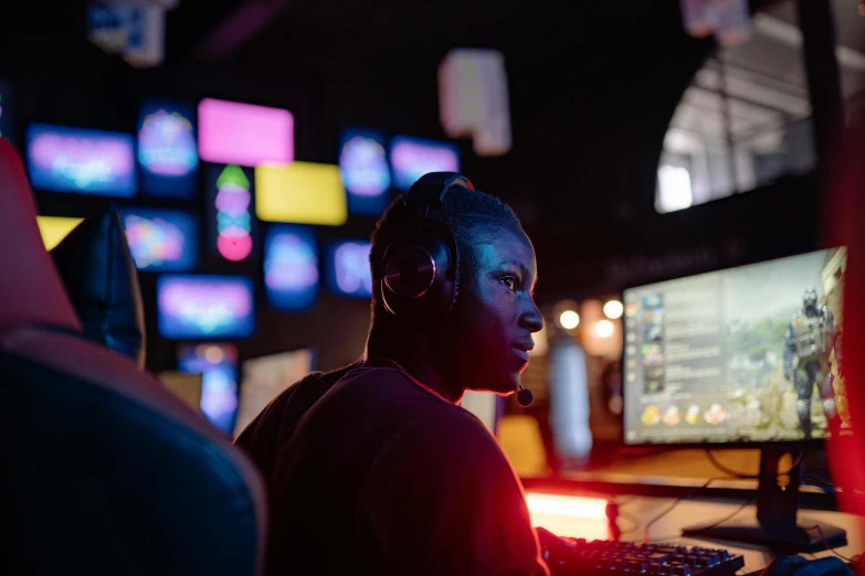 a man wearing headphones sitting in front of a computer, pexels, happening, tv screens, neon operator, server in the middle, mkbhd