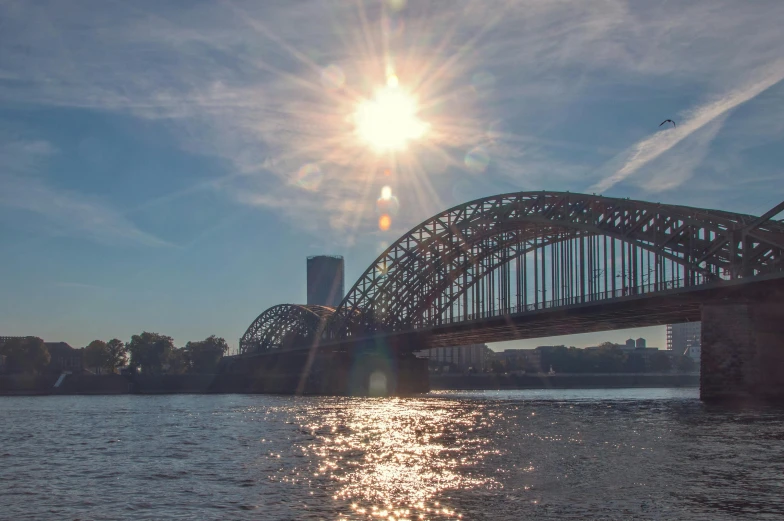 a bridge over a large body of water, a picture, by Niko Henrichon, pexels contest winner, sun and shadow over a city, thumbnail, liege, hell gate