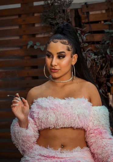 a woman in a fuzzy pink outfit smoking a cigarette, an album cover, inspired by Gina Pellón, trending on pexels, black hair in braids, arab ameera al-taweel, cl, mexican