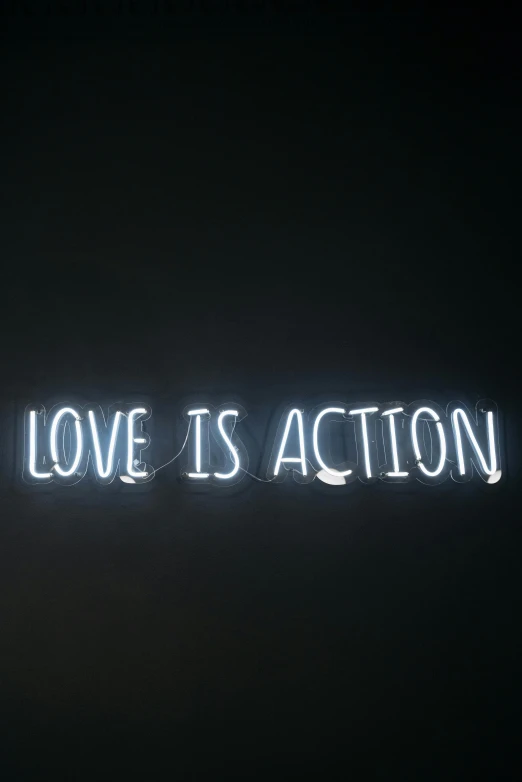 a neon sign that says love is action, pexels, in white lettering, quotev, profile image, raphael personnaz