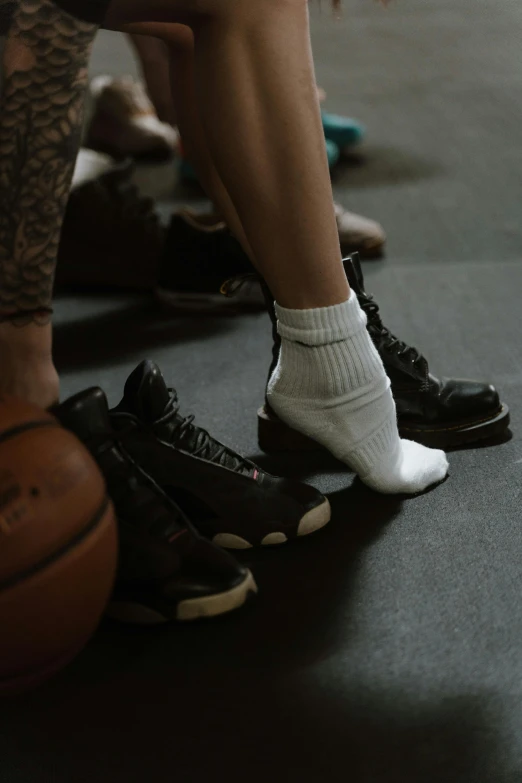 a group of people sitting on top of a basketball court, socks, bella poarch, detailed foot shot, dark taint :: athletic