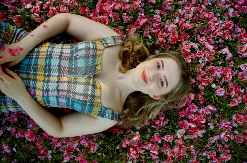 a woman laying in a field of pink flowers, a portrait, by Carey Morris, beautiful taissa farmiga, smiling down from above, avatar image, sydney sweeney