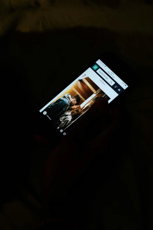 a person holding a cell phone in the dark, a picture, by Android Jones, happening, movie frame, a high angle shot, a wooden, with a whitish