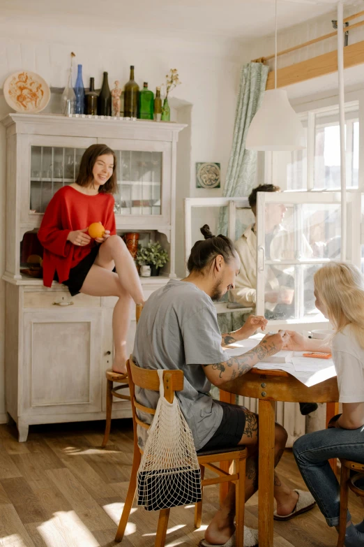 a group of people sitting around a wooden table, a picture, cute kitchen, profile image, apartment, environmental shot